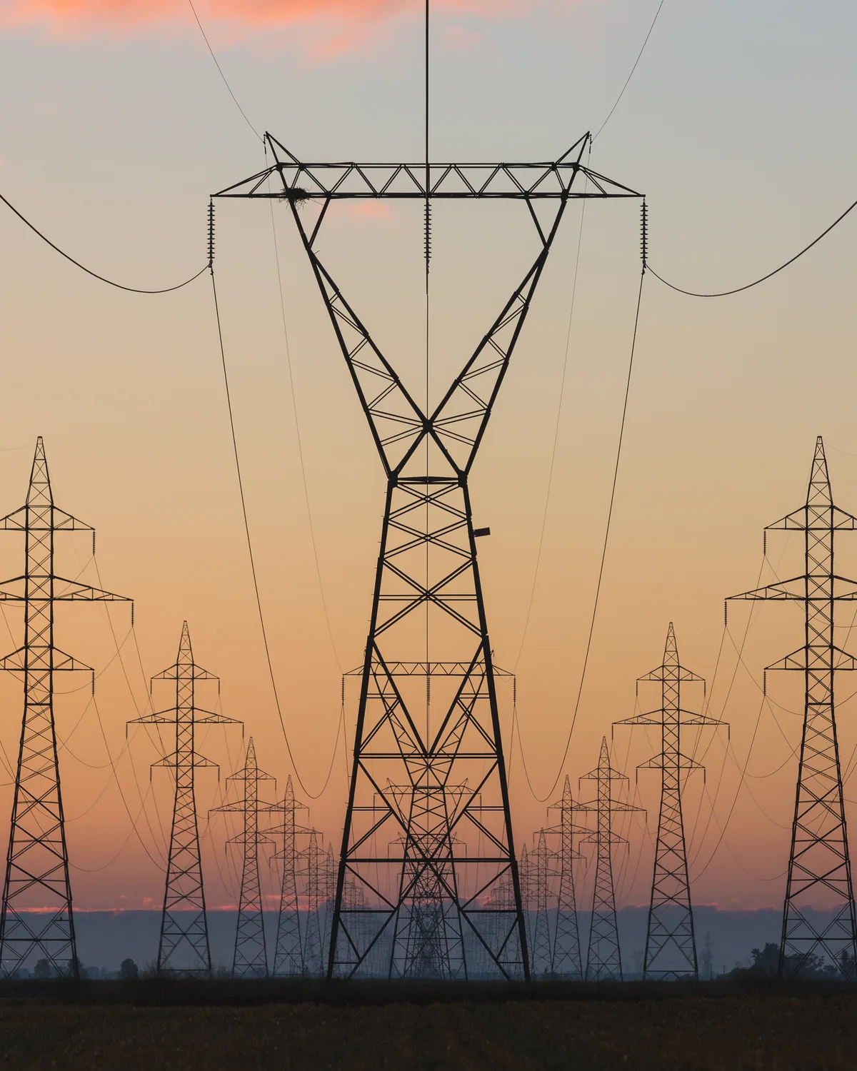 High-voltage transmission pylons at sunrise